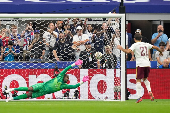 Spain's Mikel Oyarzabal scores the opening goal from the penalty spot past France goalkeeper Mike Maignan during the World Cup semifinal soccer match between France and Spain in Arlington, Texas, near Dallas, Tuesday, July 14, 2026. (AP Photo/Ashley Landis)