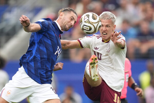 France's Adrien Rabiot (14) and Spain's Dani Olmo (10) go after the ball during the World Cup semifinal soccer match between France and Spain in Arlington, Texas, near Dallas, Tuesday, July 14, 2026. (AP Photo/Eric Gay)