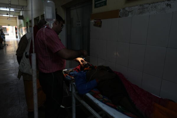 Dr. Abhishek Pranayami examines a patient suffering from a heat-related illness amid high temperatures at a district government hospital in Banda, northern Indian state of Uttar Pradesh, Friday, June 19, 2026 (AP Photo/Rajesh Kumar Singh)