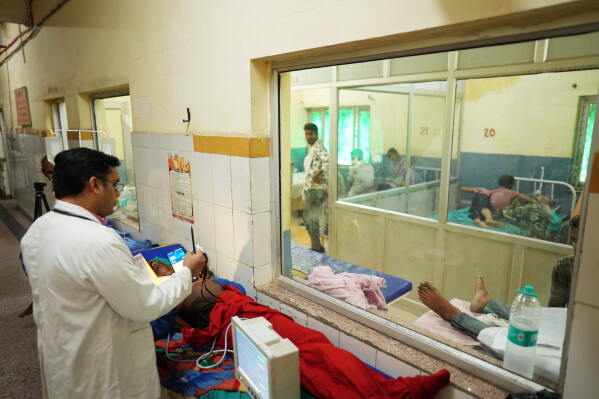 Dr. Abhishek Pranayami examines a patient suffering from a heat-related illness amid high temperatures at a district government hospital in Banda, northern Indian state of Uttar Pradesh, Friday, June 19, 2026 (AP Photo/Rajesh Kumar Singh)
