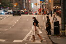 A woman wearing a mask crosses the street in Toronto as wildfire smoke fills the city, on Wednesday, July 15, 2026. (Laura Proctor/The Canadian Press via AP)