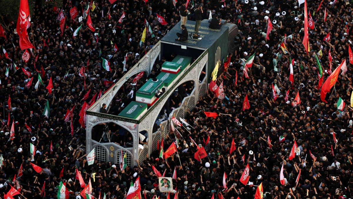 Mourners gather around a vehicle transporting the coffin of Iran's late Supreme Leader Ayatollah Ali Khamenei