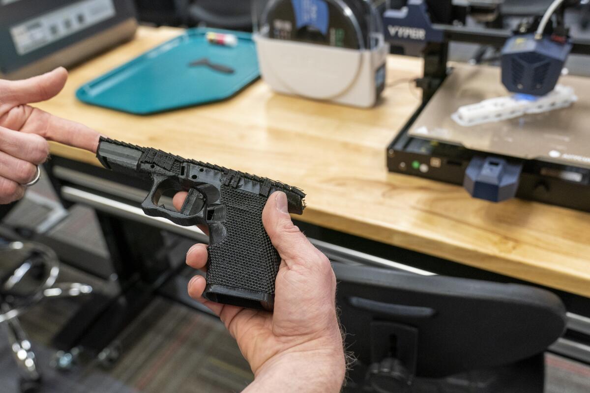 A black handgun frame in a person's hand