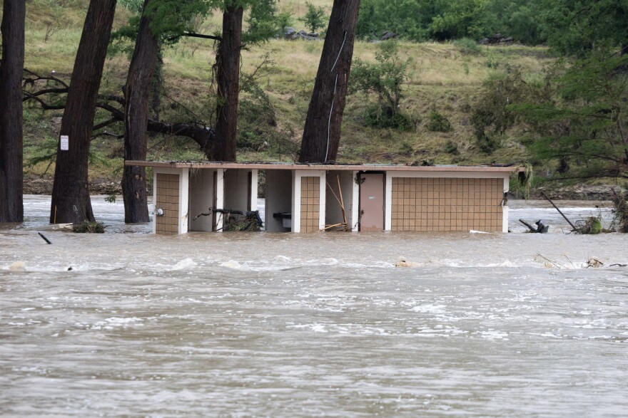 A structure sits half way underwater in a river.