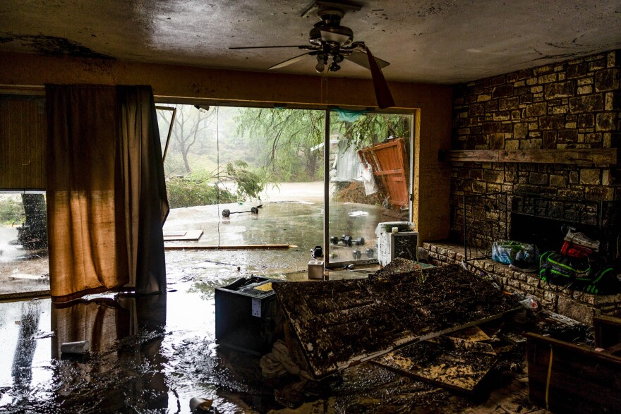 Mud and standing water can be seen inside a home that was flooded.