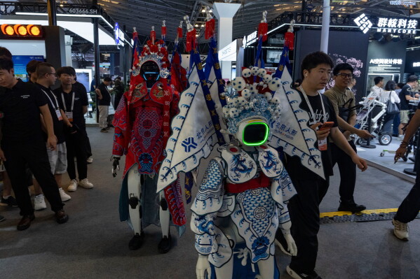 Robots wearing traditional Chinese opera costumes walk around the booths at the World AI Conference in Shanghai, Friday, July 17, 2026. (AP Photo/Ng Han Guan)
