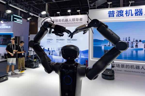 A robot from Pudu Robotics, a Chinese robotics company welcomes visitors to the World AI Conference in Shanghai, Friday, July 17, 2026. (AP Photo/Ng Han Guan)