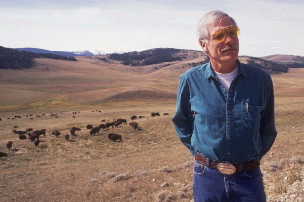 Ted Turner poses near a herd of his bison in September 1991 at his Flying D Ranch near Bozeman, Mont. (Linda Best/Bozeman Daily Chronicle via AP, File)