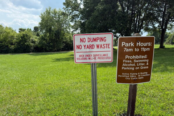 Signs are posted inside the Riverside Dr Scioto Fishing Area on Tuesday, July 21, 2026, in Powell, Ohio. (AP Photo/Patrick Aftoora-Orsagos)