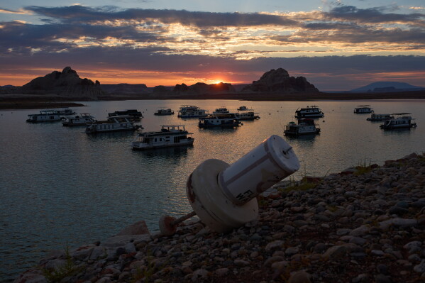 A formerly floating buoy now sits high and dry above Lake Powell at the Glen Canyon National Recreation Area, Wednesday, July 15, 2026, near Page, Nev. (AP Photo/John Locher)