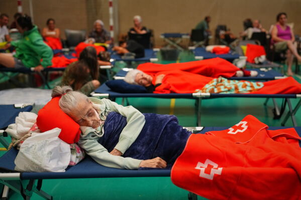 Residents spend the night at a sports center after being evacuated from their homes because of the threat of a wildfire in Cebreros, Ávila province, Spain, Friday, July 24, 2026. (AP Photo/Manu Fernandez)