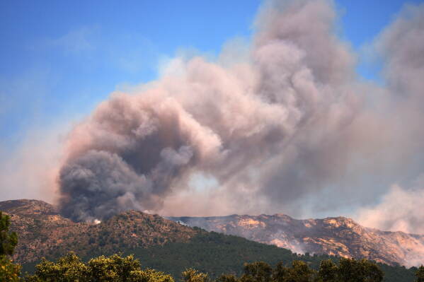 Smoke and flames rise as a wildfire advances near La Adrada, Ávila province, Spain, Friday, July 24, 2026. (AP Photo/Manu Fernandez)