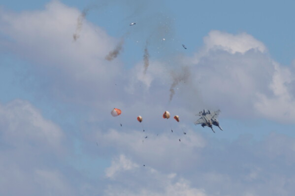 Crew members parachute down after two U.S. Navy planes collided during an air show at the Mountain Home Air Force Base, Sunday, May 17, 2026, near Mountain Home, Idaho. (Henk Zuurbier via AP)