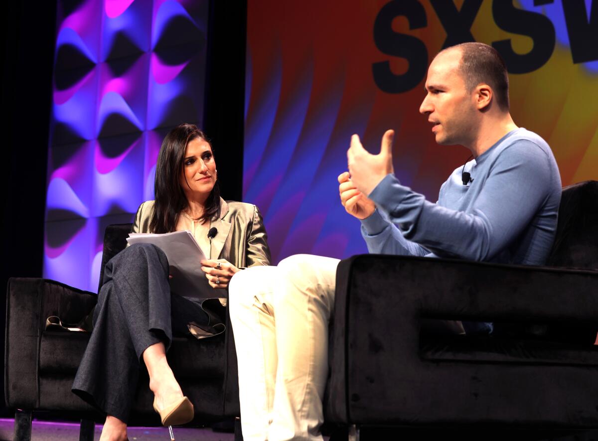 Greg Brockman, right, speaks onstage at the 2023 SXSW Conference. 