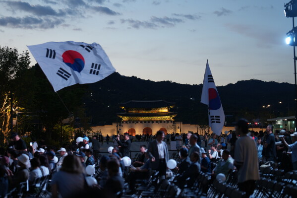 People hold national flags after a ceremony to mark the 76th anniversary of the outbreak of the Korean War in Seoul, South Korea, Tuesday, June 23, 2026. (AP Photo/Lee Jin-man)