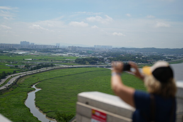 Military barbed-wire fences are placed along the express road Jayuro, with a view of the landscape of Paju visible beyond them in Paju, South Korea, Tuesday, July 7, 2026. (AP Photo/Lee Jin-man)