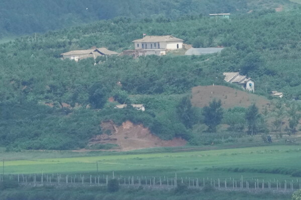 A North Korean flag, center top, flutters in the wind on North Korea's town, Kaepoong, as seen from the unification observatory in Paju, South Korea, Tuesday, July 7, 2026. (AP Photo/Lee Jin-man)