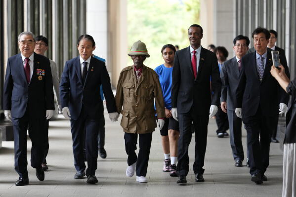 Ethiopian veteran of the Korean War, Tesfaye Asmamaw, 95, walks with South Korean minister of Patriots and Veterans Affairs, Kwon Oh-eul, second from left, in Seoul, South Korea, Tuesday, June 30, 2026. (AP Photo/Lee Jin-man)