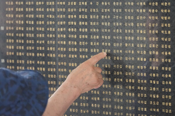 A South Korean man points a name of his brother who was killed in the Korean War in Seoul, South Korea, Sunday, July 5, 2026. (AP Photo/Lee Jin-man)