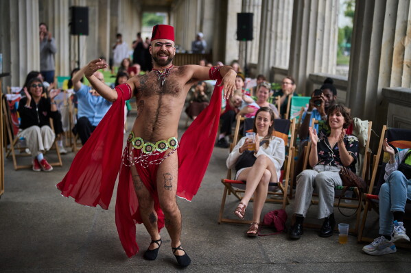 Haidar Darwish, a Syrian belly dancer with the Berlin-based LGBTQ collective Queens Against Borders, performs during an open-air show in Berlin, Germany, Sunday, July 26, 2026. (AP Photo/Ebrahim Noroozi)