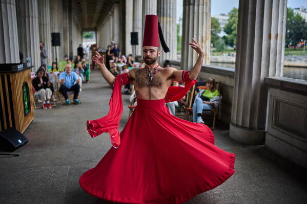 Haidar Darwish, a Syrian belly dancer with the Berlin-based LGBTQ collective Queens Against Borders, performs during an open-air show in Berlin, Germany, Sunday, July 26, 2026. (AP Photo/Ebrahim Noroozi)