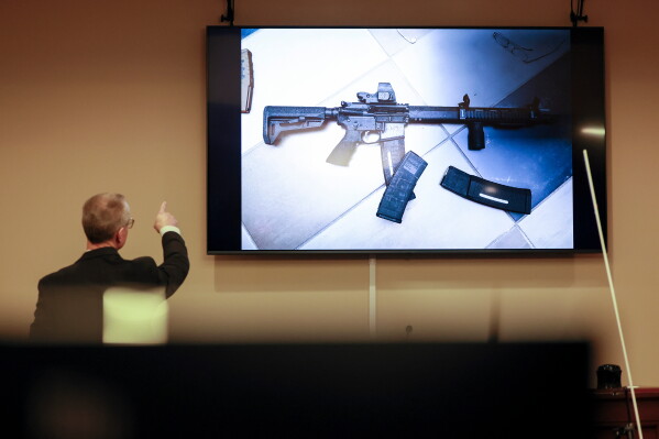 District Attorney Brad Smith, left, points to a weapon that was displayed on the screen during the first day of the trial of Colin Gray, the father of Apalachee High School shooting suspect Colt Gray, in the courtroom at the Barrow County courthouse, Feb. 16, 2026, in Winder, Ga. (Jason Getz/Atlanta Journal-Constitution via AP, File)