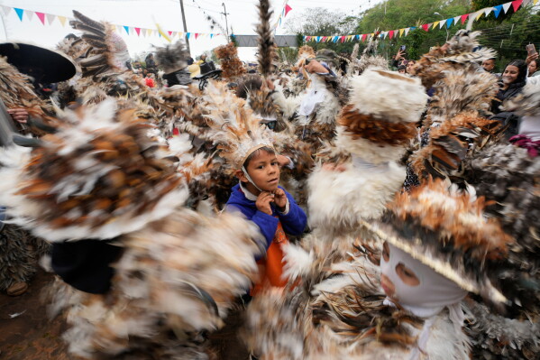Parishioners wearing a birdlike costumes dance in the annual procession honoring 16th-century St. Francis Solano in Emboscada, Paraguay, Friday, July 24, 2026. (AP Photo/Jorge Saenz)