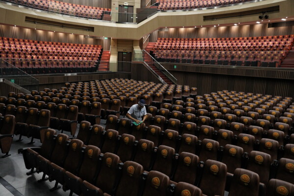A janitor wipes chairs at the Universidad Santiago de Cali auditorium, where President-elect Abelardo de la Espriella will be inaugurated, in Cali, Colombia, Wednesday, July 29, 2026. (AP Photo/Santiago Saldarriaga)