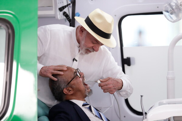 Brazilian President Luiz Inácio Lula da Silva pretends to examine World Health Organization Director-General Tedros Adhanom Ghebreyesus with dental equipment during a visit to the Andaraí Hospital in Rio de Janeiro, Brazil, Tuesday, July 28, 2026. (AP Photo/Bruna Prado)