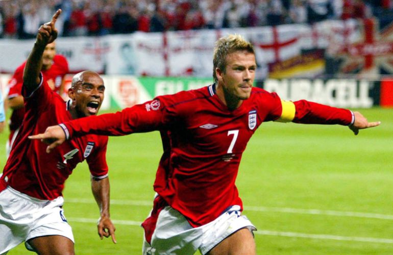 England captain David Beckham (R) runs in celebration with team mate Trevor Sinclair after scoring from the penalty spot against Argentina