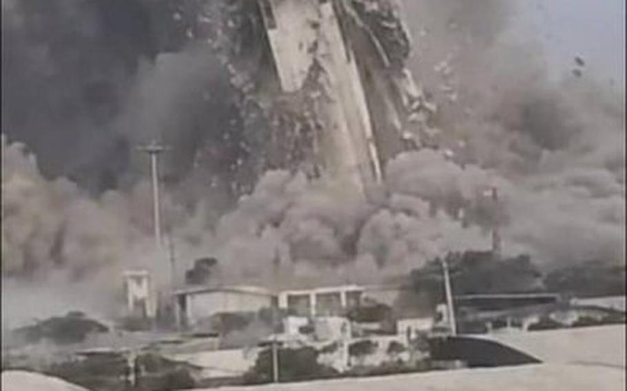 A surveillance tower appears to collapse in the desert.