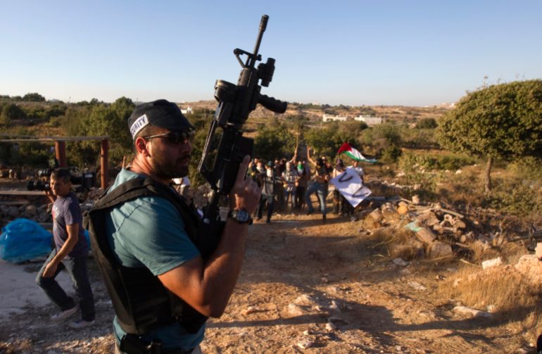 A Jewish settler stands guard as settlers dressed as Palestinian protesters participate in a drill, held by the settler's security response teams, simulating violence that could erupt ahead of the upcoming Palestinian bid for statehood at the United Nations September 14, 2011, in the West Bank settlement of Kiryat Arba. REUTERS/Ronen Zvulun (WEST BANK - Tags: POLITICS CIVIL UNREST)