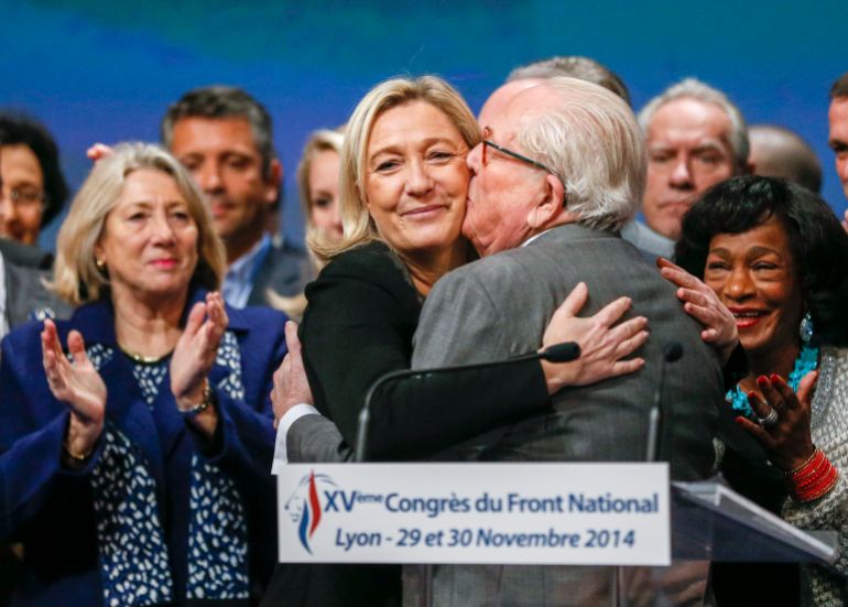 Marine Le Pen (C), France's National Front political party leader, reacts with her father Jean-Marie Le Pen (R) after being re-elected during their congress in Lyon November 30, 2014. REUTERS/Robert Pratta (FRANCE - Tags: POLITICS TPX IMAGES OF THE DAY)