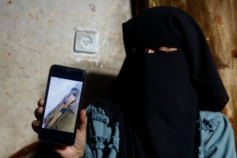Rana Abu Nassar, mother of Palestinian prisoner Osama Abu Nassar who is held by Israel, holds a mobile phone displaying a widely circulated image that she believes shows her son restrained while in Israeli custody, at her home in Al-Maghazi refugee camp, central Gaza Strip, July 3, 2026. The image has sparked a desperate search for the man's identity, with two Palestinian families claiming him as their son. REUTERS/Mahmoud Issa