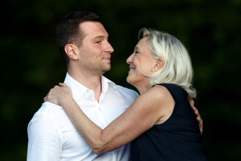 French far-right leader Marine Le Pen and Jordan Bardella, president of the French far-right Rassemblement National (National Rally - RN) political party, embrace after speaking at a country fair with supporters in Lievin, northern France, July 4, 2026. REUTERS/Tom Nicholson TPX IMAGES OF THE DAY