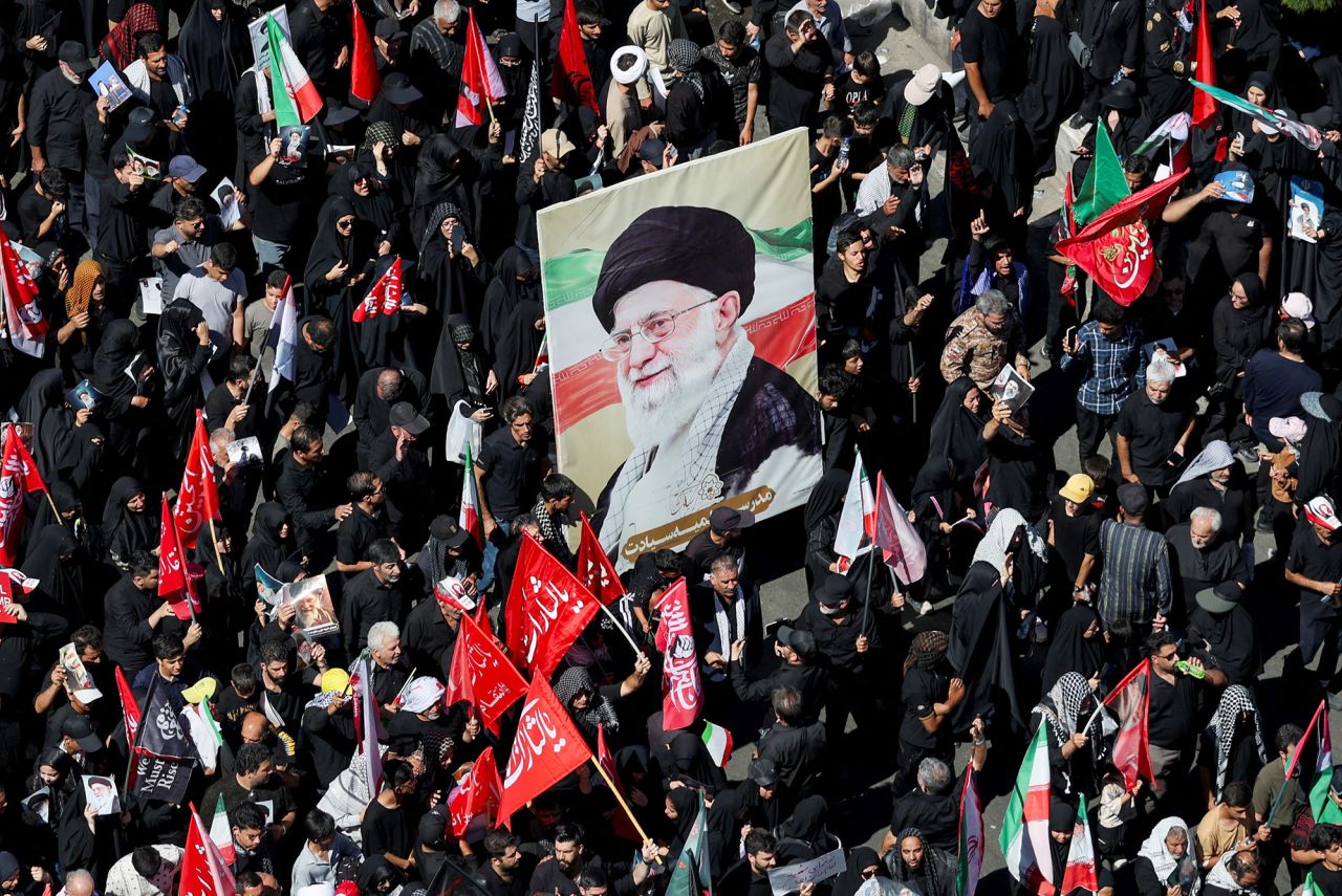 Mourners carry a portrait of Iran's late Supreme Leader Ayatollah Ali Khamenei as they gather on the day of his burial, in Mashhad, Iran.