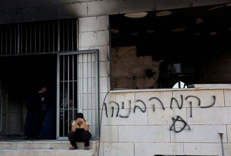 A Palestinian boy sits outside a mosque damaged by Israeli settlers, in Qusra near Nablus, in the Israeli-occupied West Bank, July 26, 2026