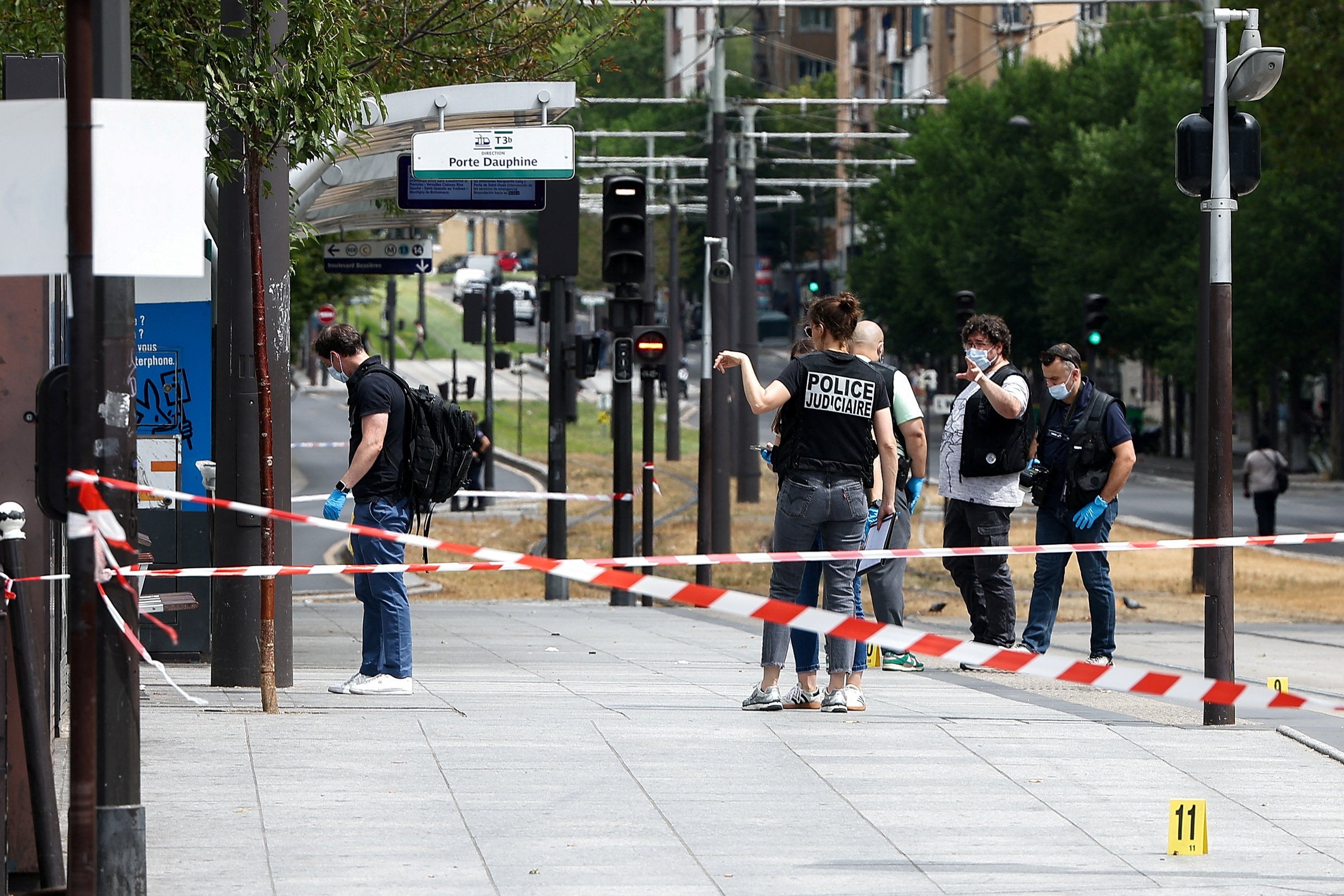 Police officers work at the site of a knife attack near the Porte de Clichy in Paris