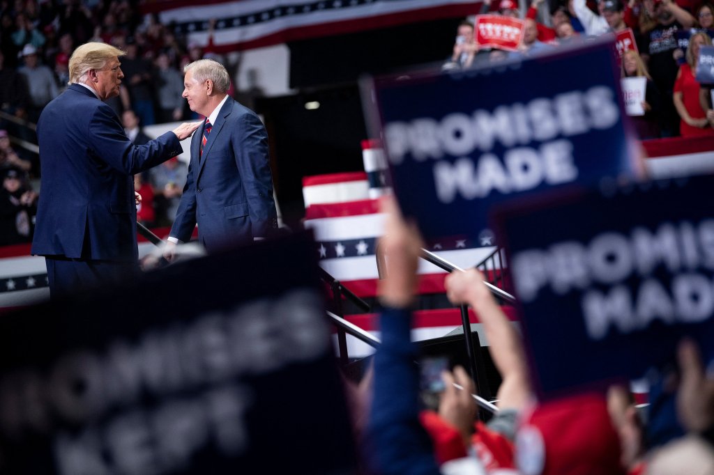 Donald Trump pats Senator Lindsey Graham on the shoulder at a rally.