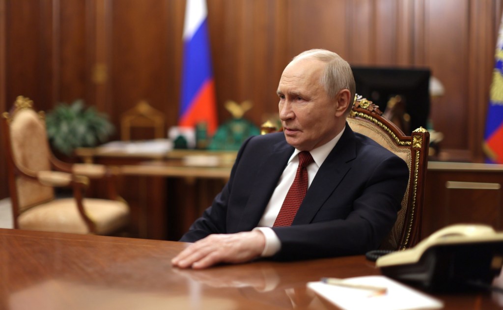 Russian President Vladimir Putin answers questions from a television host during an interview at the Kremlin.