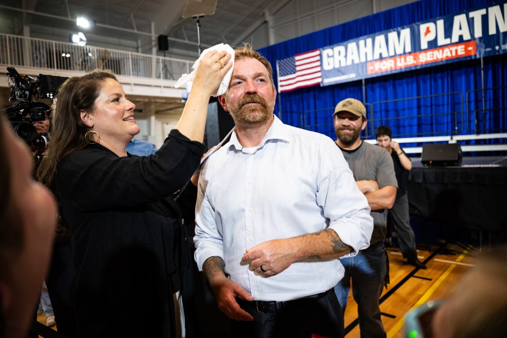 Amy Gertner wipes sweat from Democratic US Senate candidate Graham Platner's forehead during a primary election night event.