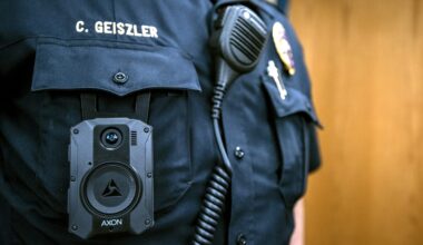 A body camera is clipped onto the pocket of a police officer's uniform.