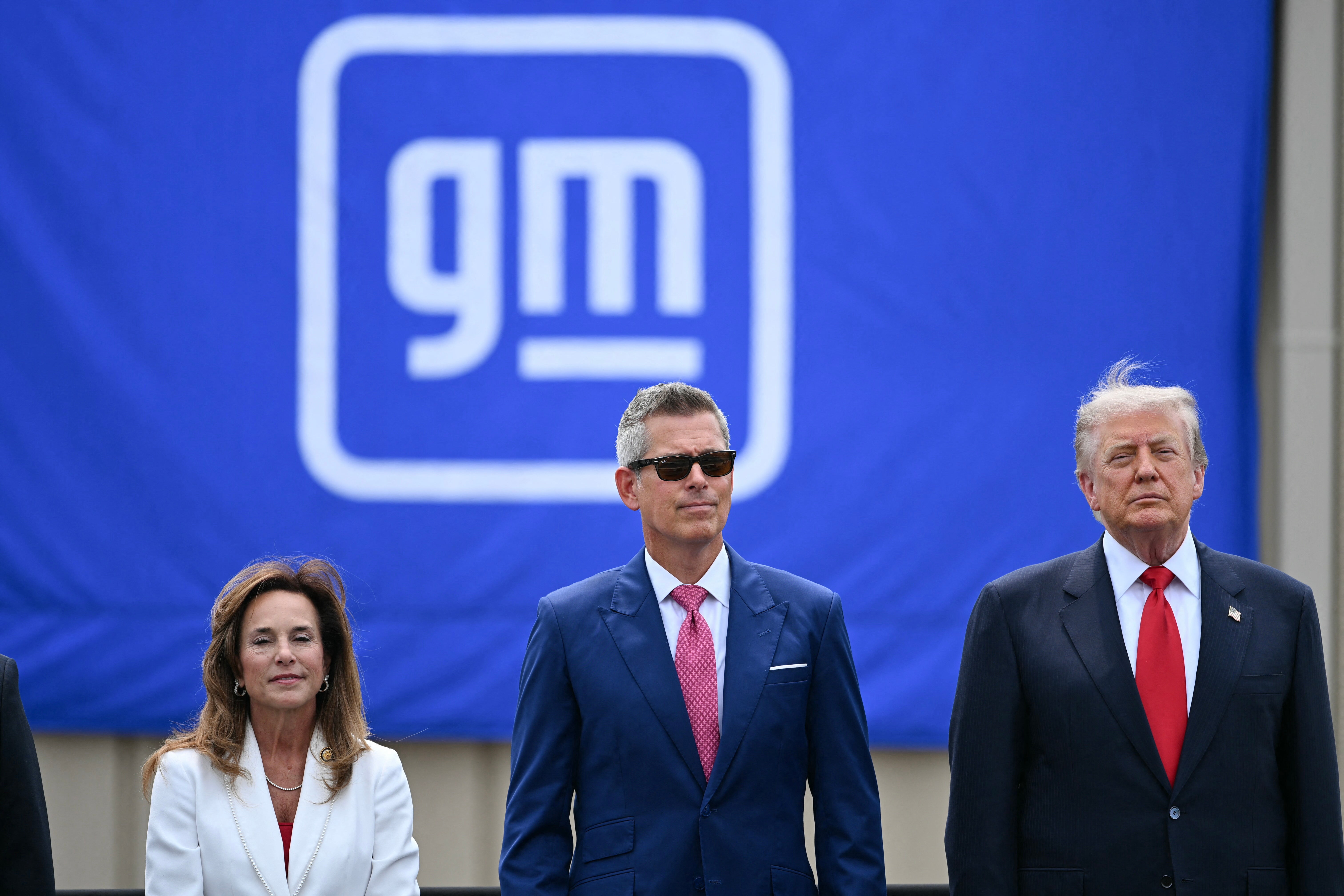Trump is joined by, L/R, Representative Lisa McClain, Republican from Michigan and US Secretary of Transportation Sean Duffy in Michigan this week