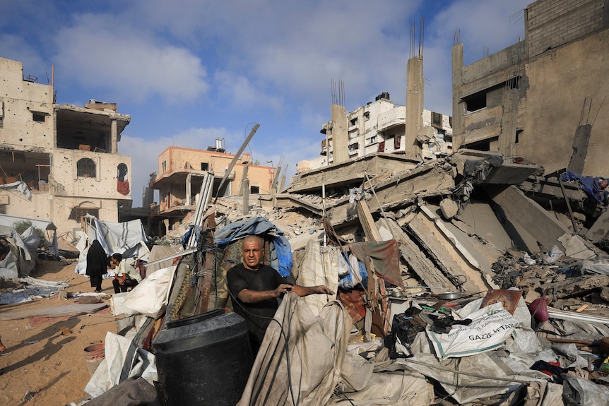 A man sits in a destroyed building.