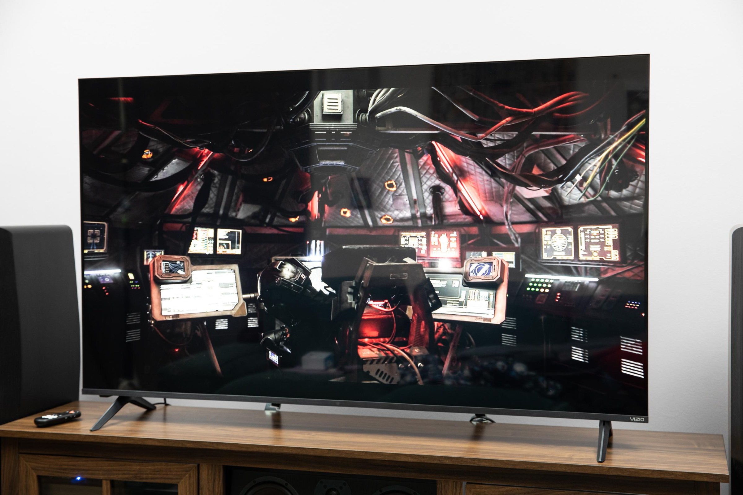 The Vizio Mini LED Quantum displaying an image from The Expanse, sitting on a wooden credenza.