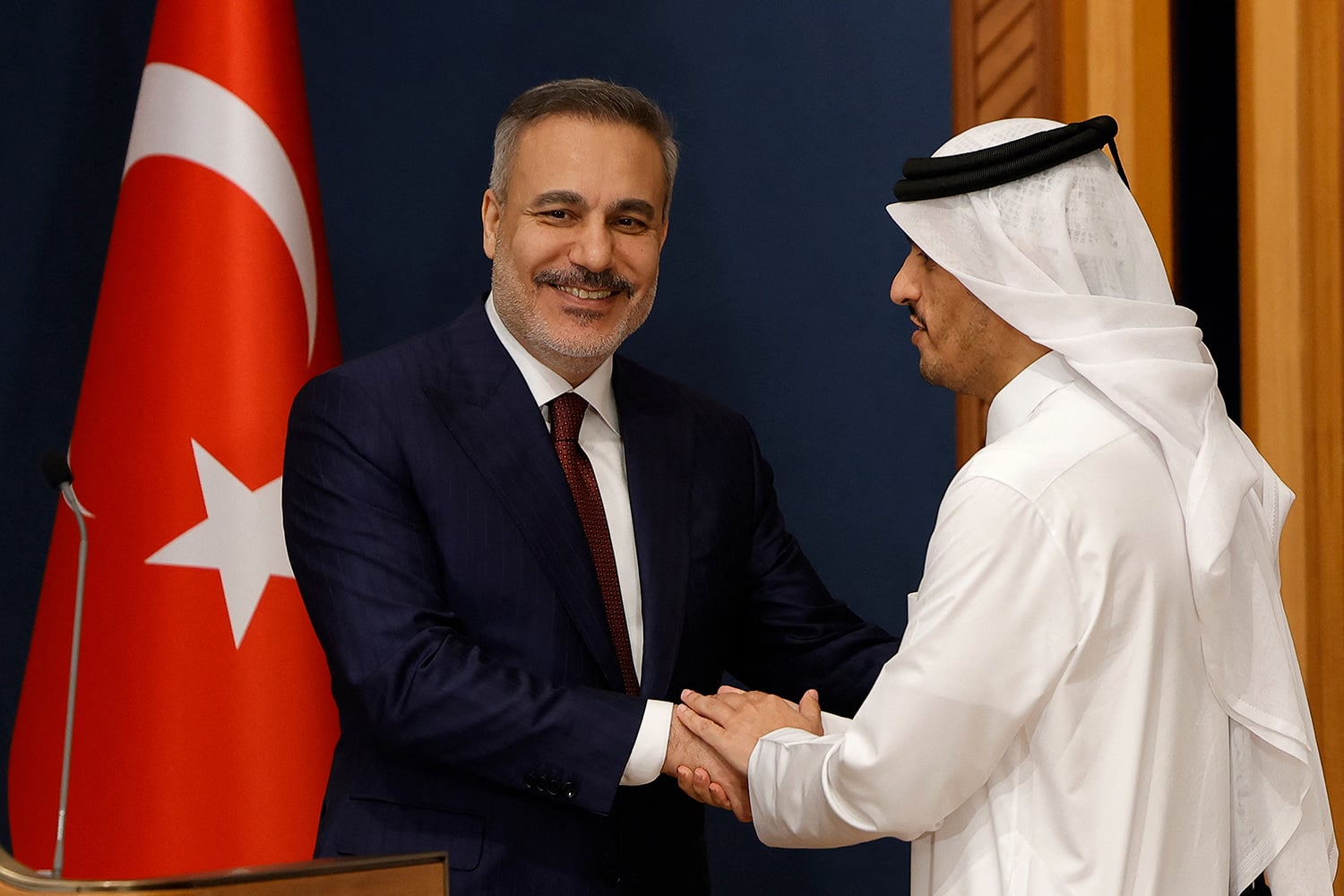 Turkish Foreign Minister Hakan Fidan, left, shakes hands with al-Thani after a joint news conference in Doha.