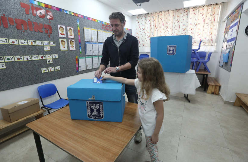 (Illustrative) A child helps cast a vote by placing a ballot in a box in Jerusalem's Baka neighborhood, April 9th, 2019