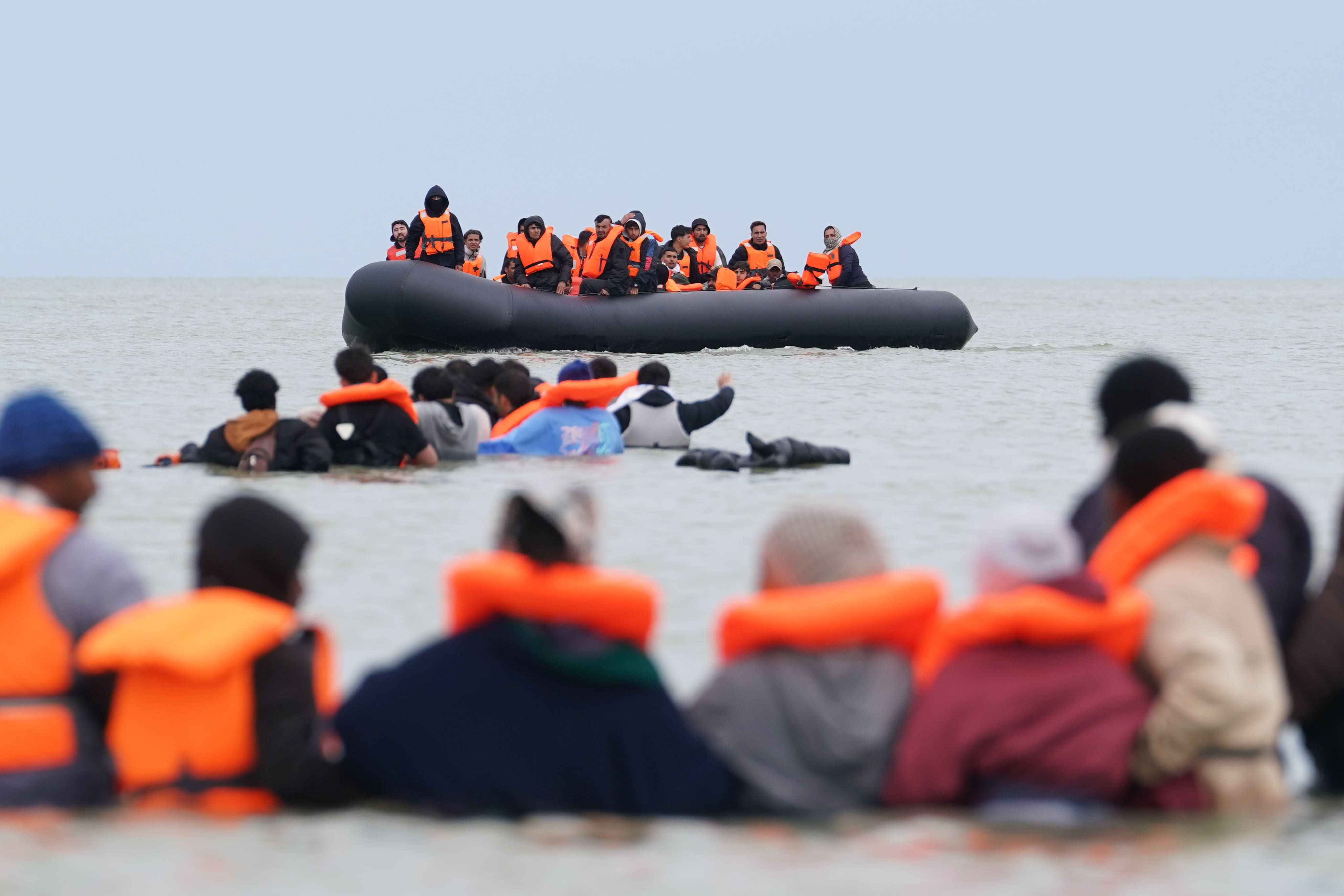 People thought to be migrants wade in the water as they attempt to board a small boat off the coast of Berck, France, during an attempt to cross the English Channel on 15 June 2026