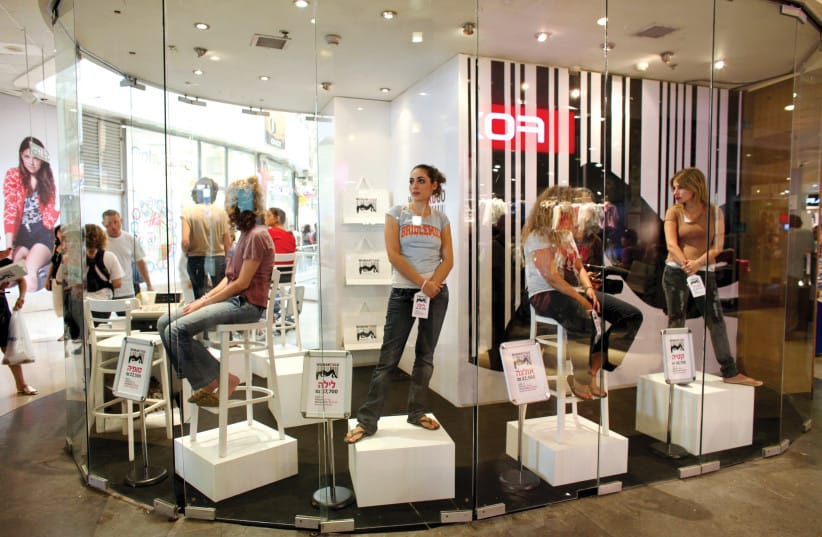 Women with price tags on their hands are displayed in the window of a store called Woman To Go in a shopping mall in Tel Aviv to raise awareness about and protest against the trafficking of women.
