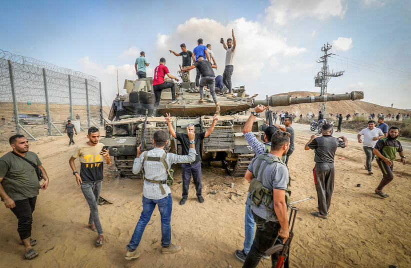 Palestinians take control of an Israeli tank after crossing the border fence with Israel from Khan Yunis in the southern Gaza Strip, October 7, 2023.